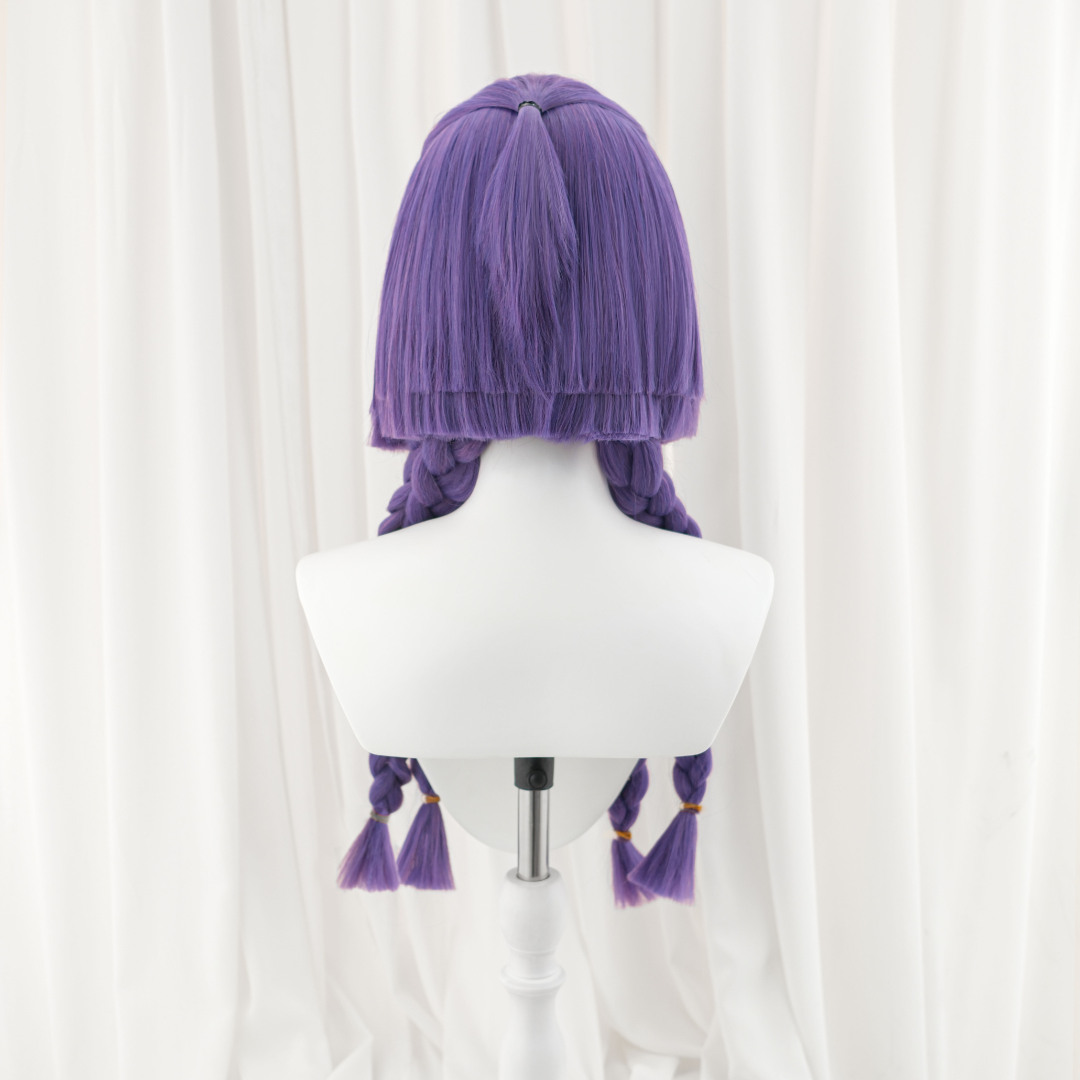 Purple wig on a mannequin head against a white background